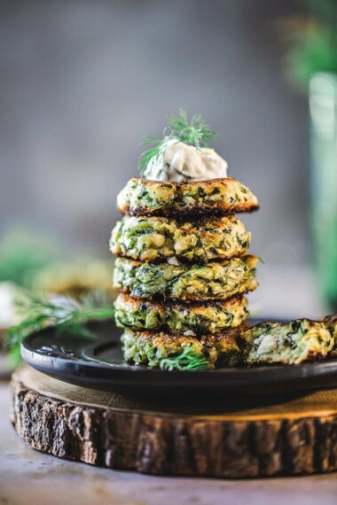 Zucchini Fritters with dill, feta and Tzatziki Sauce, a simple easy way to use up summer squash and zucchini! Healthy and light! #zucchinifritters #zucchinicakes #zucchinirecipes