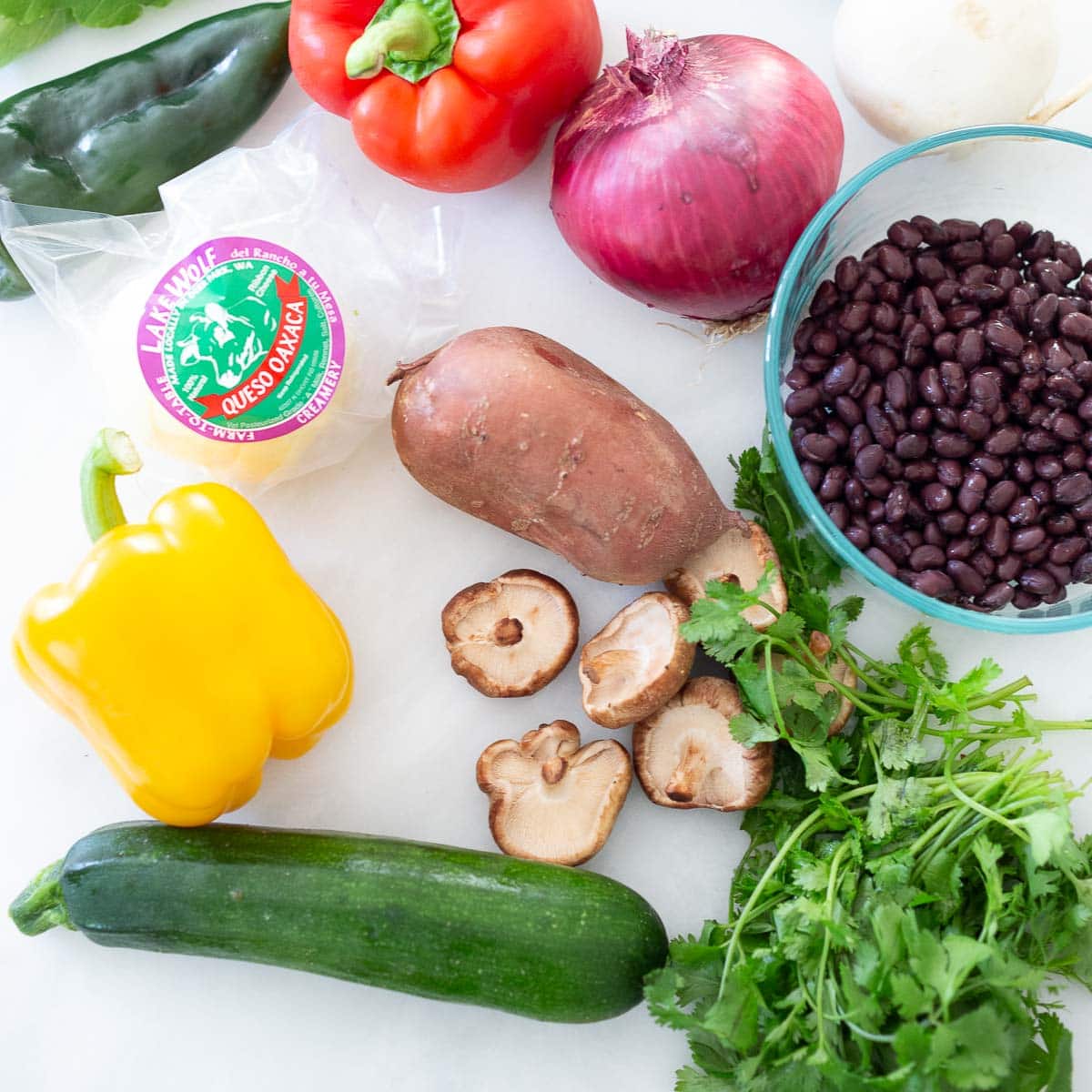 vegetarian enchilada ingredients: black beans, onion, bell pepper, mushrooms, sweet potatoes, cheese, cilantro.