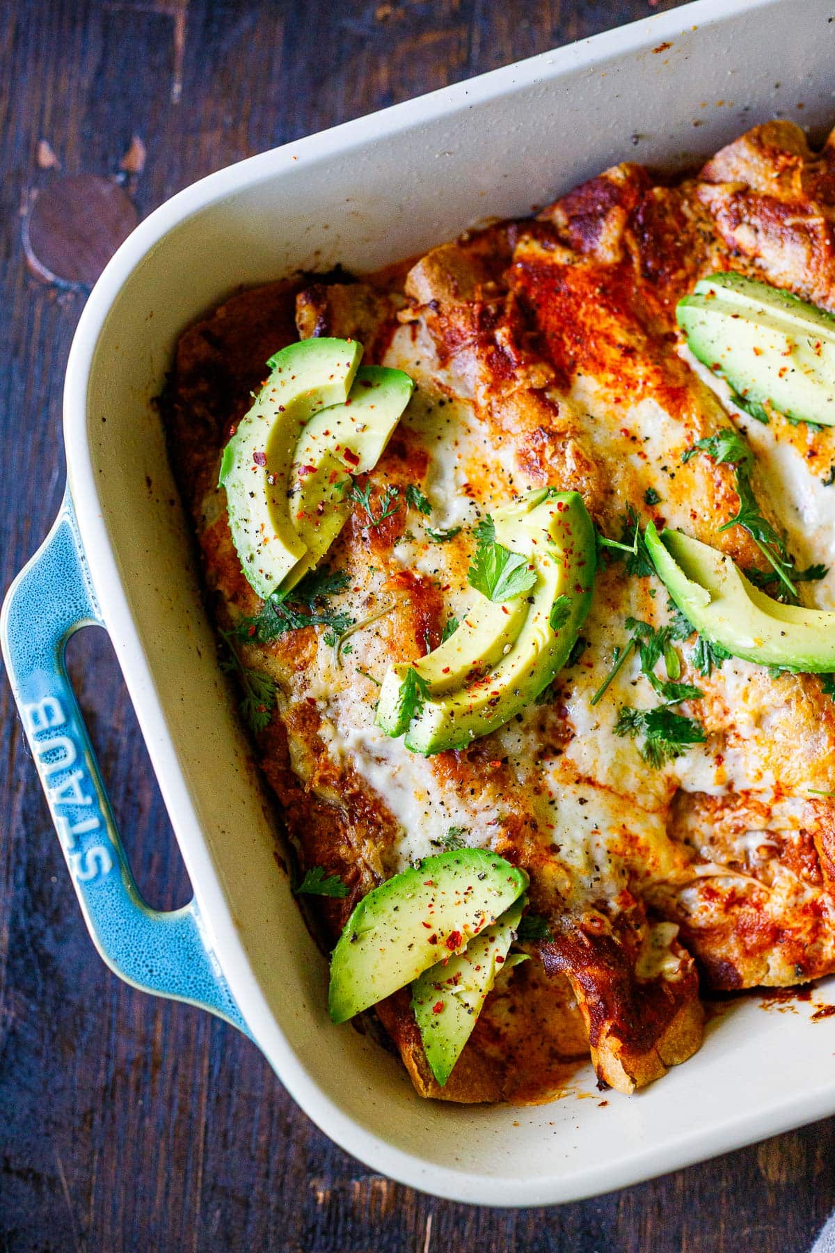 vegetable enchiladas with avocado and cilantro on top.