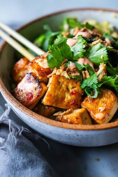 This vegan Tofu Bowl is full of protein and bursting with flavor! Made with sushi rice, edamame, cucumber, avocado, and our sticky glazed tofu, topped with crispy onions and cilantro, drizzled with vegan yum yum sauce! Gluten-free.